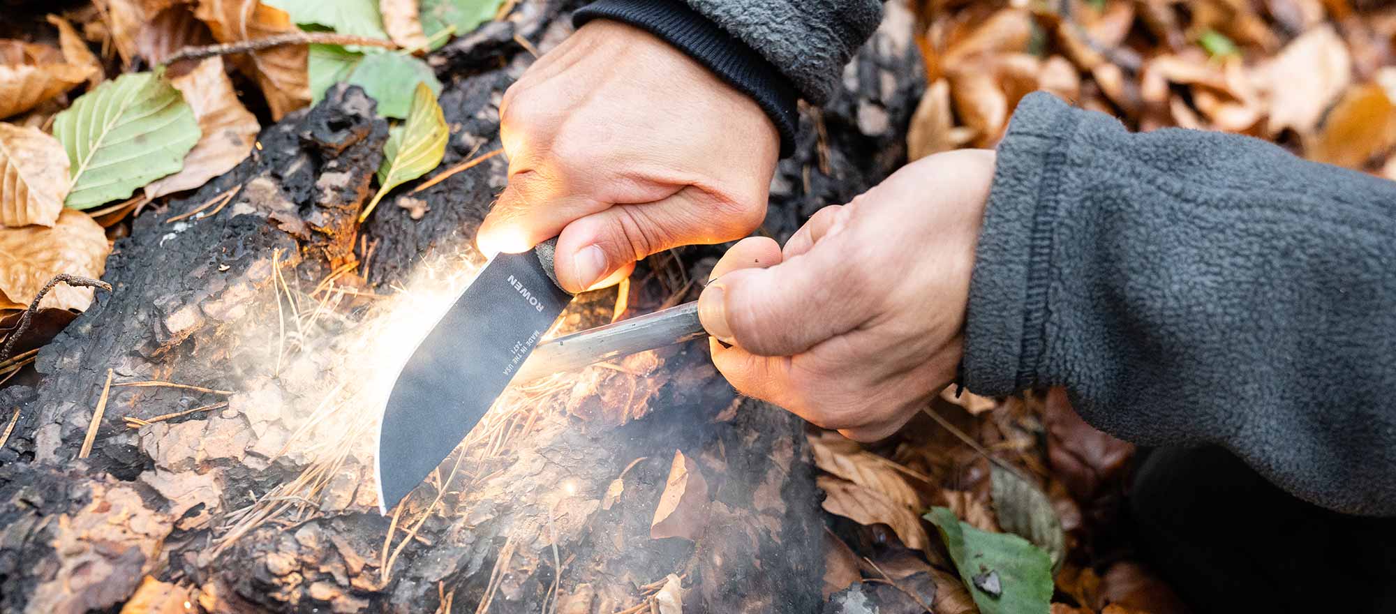 Mit dem besten Bushcraft Messer sowie Outdoormesser und einem Feuerstahl wird ein Stück Birkenrinde entfacht.
