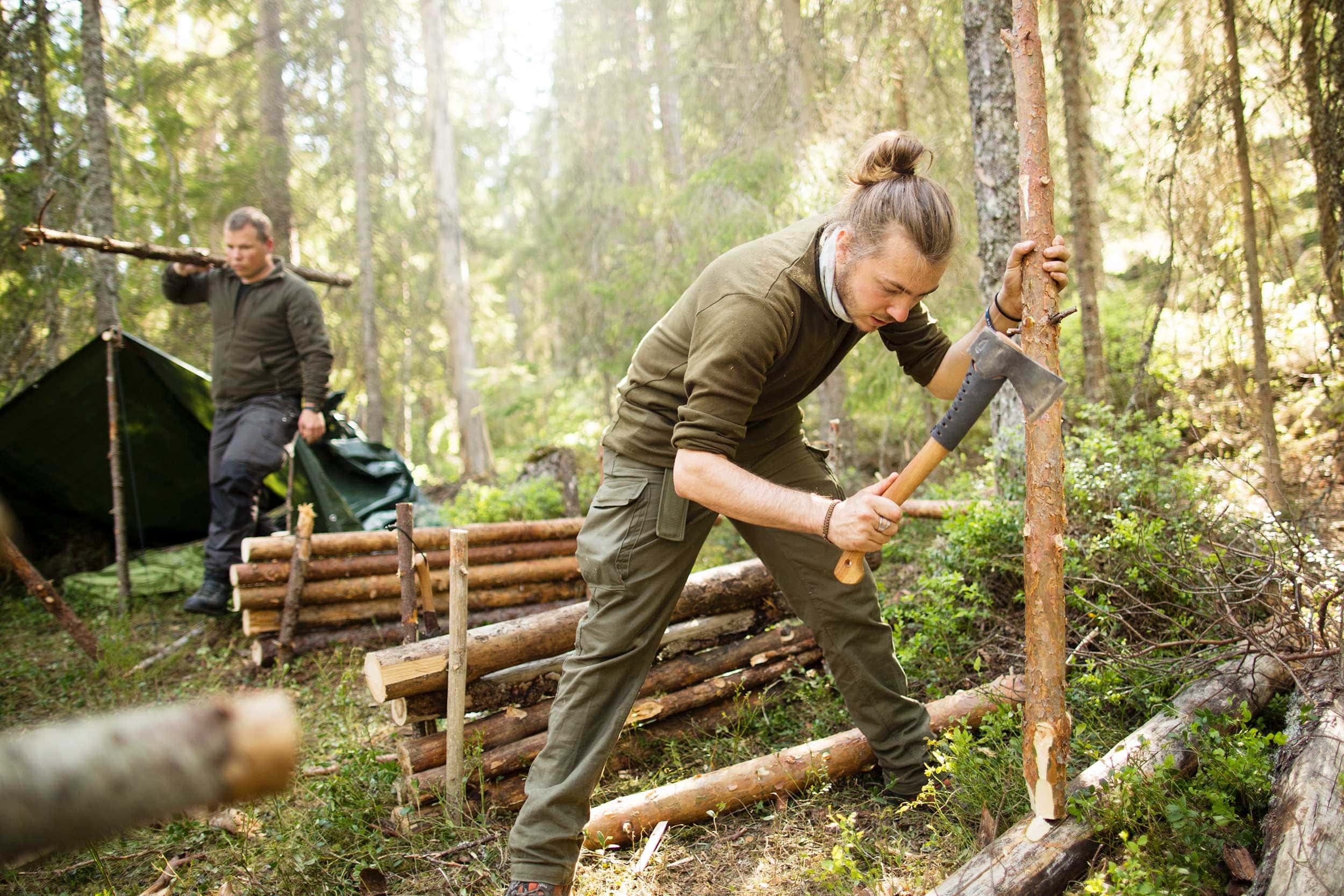 Ein Teilnehmer in unserem Bushcraft und Survival Kurs benutzt eine Axt um Holz zu bearbeiten. Bei unserem Bushcraft Kurs und Survival Training bei Berlin benutzt ein Teilnehmer eine Axt.
