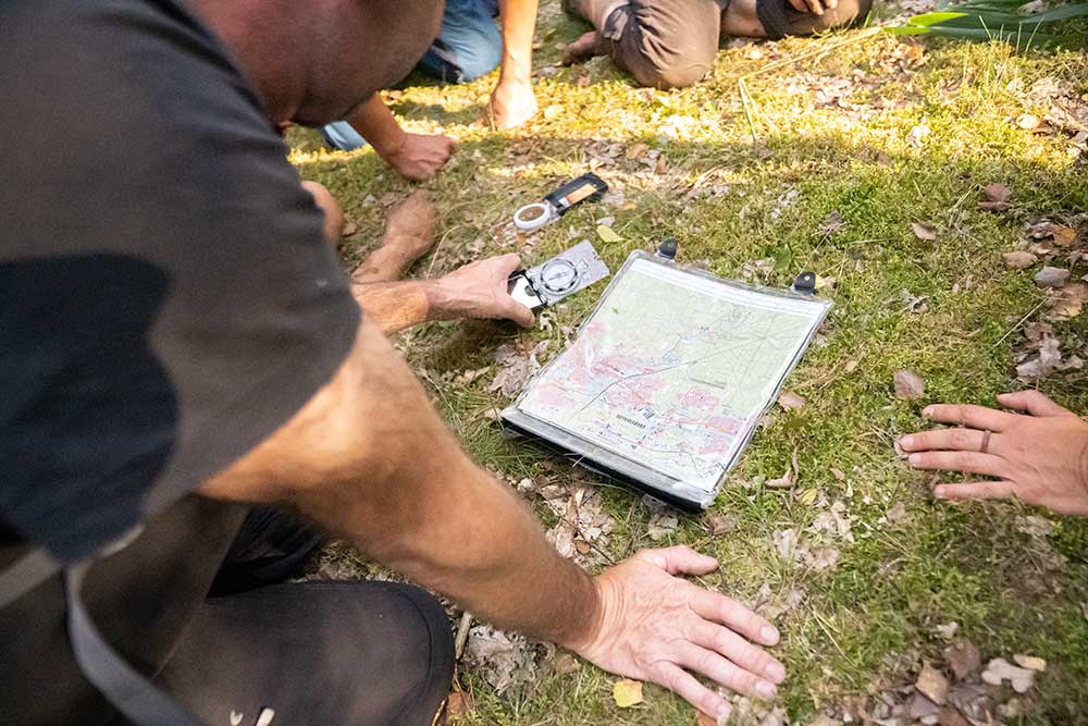 In unsere Outdoor-Survival-Training lernen die Teilnehmer gerade die Navigation mit Karte und Kompass.