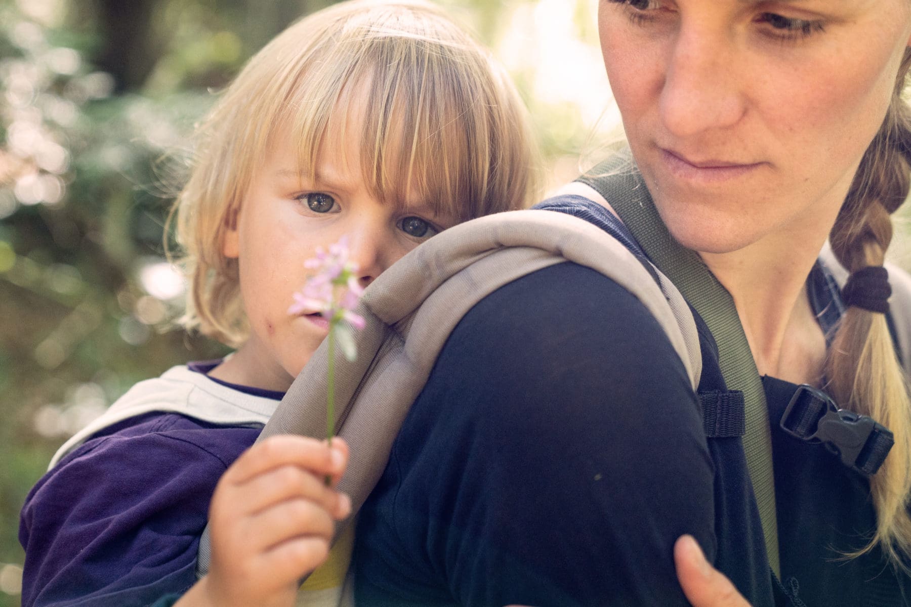 Während unserem Familiencamp betrachtet eine Teilnehmerin mit ihrem Kind eine Blüte
