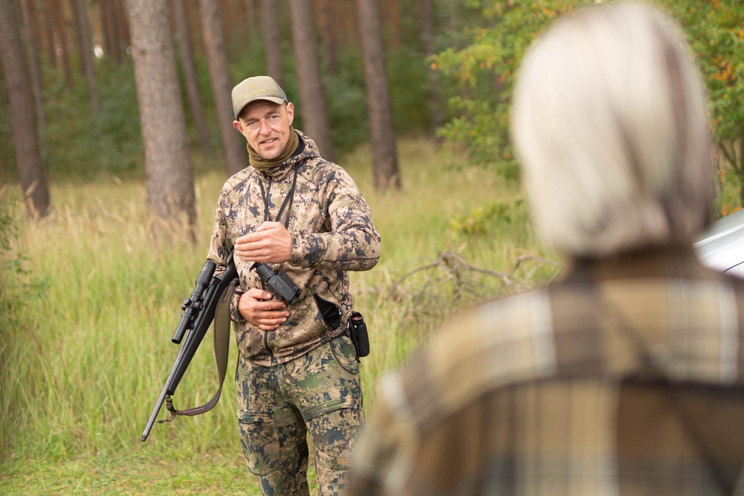Der Jagd-Dozent Kai Hagemann erklärt mit der Büchse und den Nachtzielgeräten in der Hand den Jagdschülern, wie moderne Jagdtechnik zur Pirschjagd angewendet wird.
