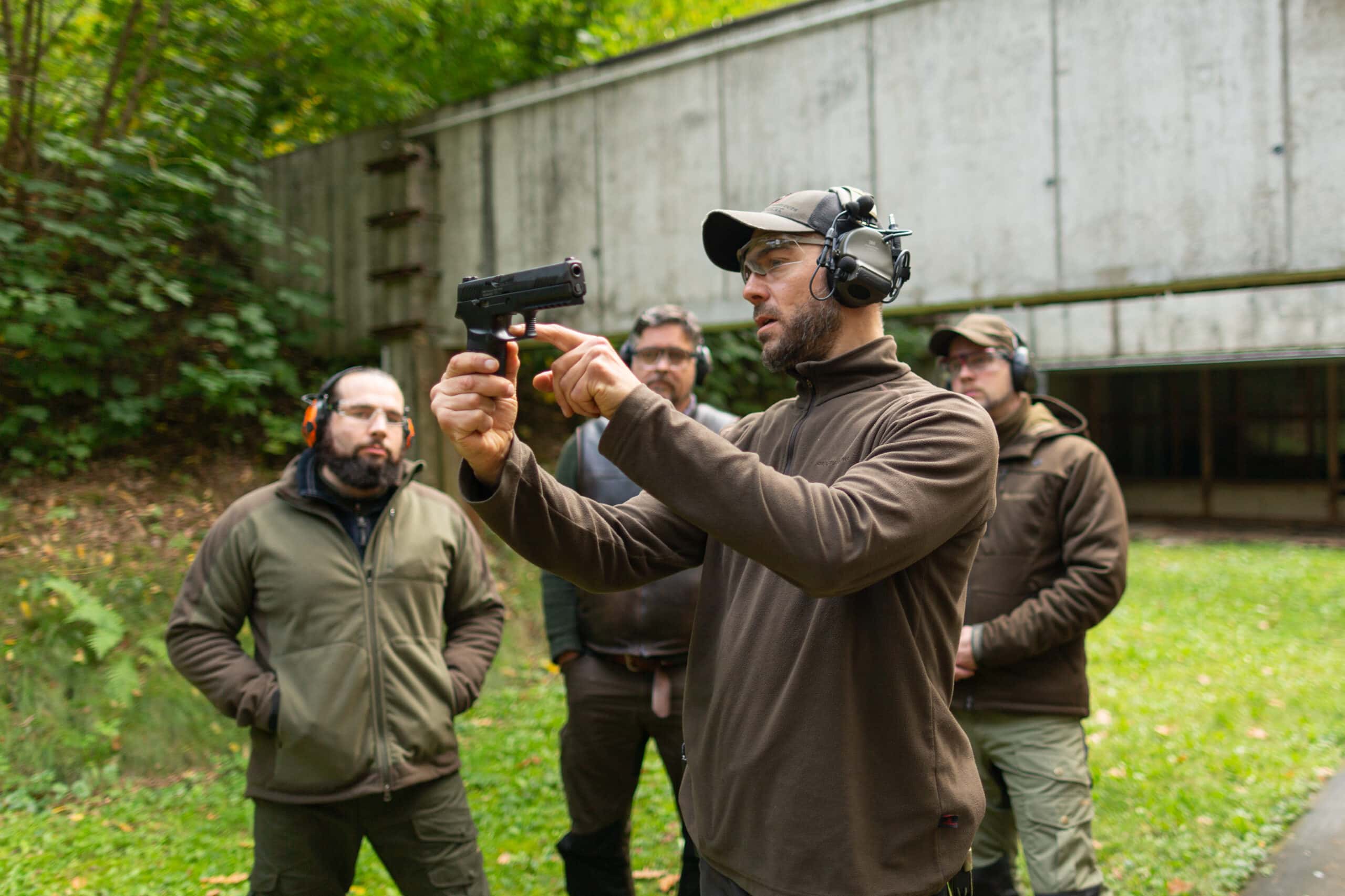 Der Ausbildungsleiter und Schießtrainer Maurice Ressel erklärt den Jagdschülern auf dem Schießplatz die Funktionsweise einer Selbstladepistole im Kaliber 9 mm Parabellum.