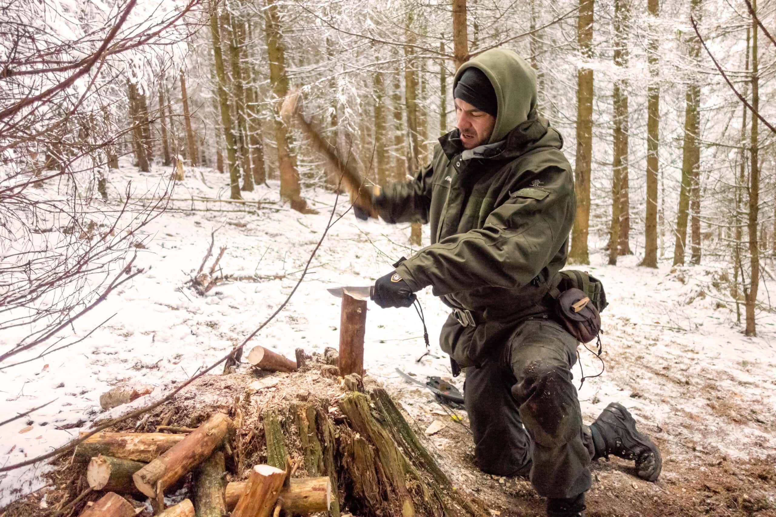Maurice Ressel beim Survival-Training im Winter – Holzverarbeitung mit der Axt im verschneiten Wald bei Brandenburg