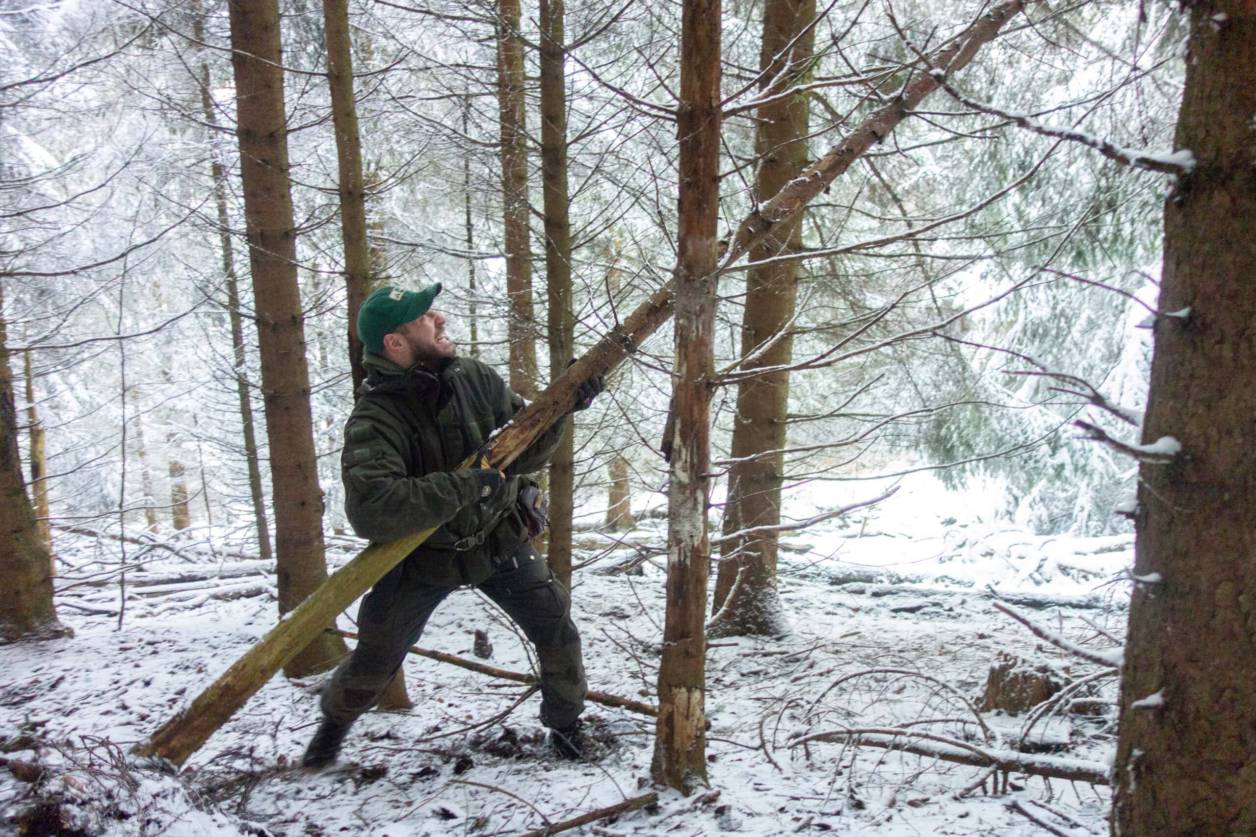 Maurice Ressel transportiert Bauholz für den Winter-Shelter — Modul 4 der Survival-Ausbildung im verschneiten Brandenburg
