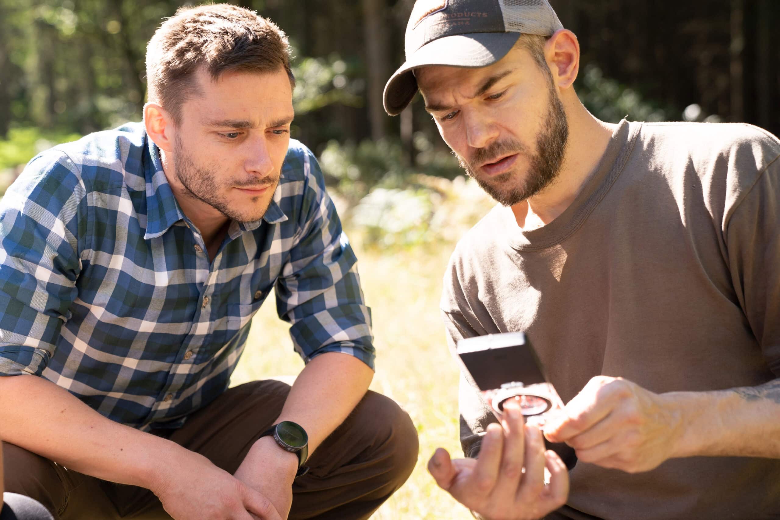 Teilnehmer der Survival-Ausbildung bei konzentrierter Teamarbeit unter Druck — angewandte Krisenpsychologie im Gelände