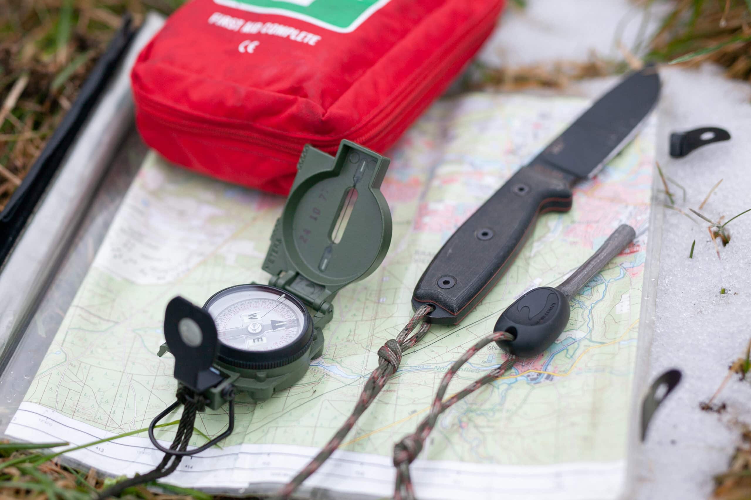 Survival-Ausrüstung mit Kompass, Erste-Hilfe-Set und Karte – die äußere Ausrüstung ergänzt Die Innere Ausrüstung