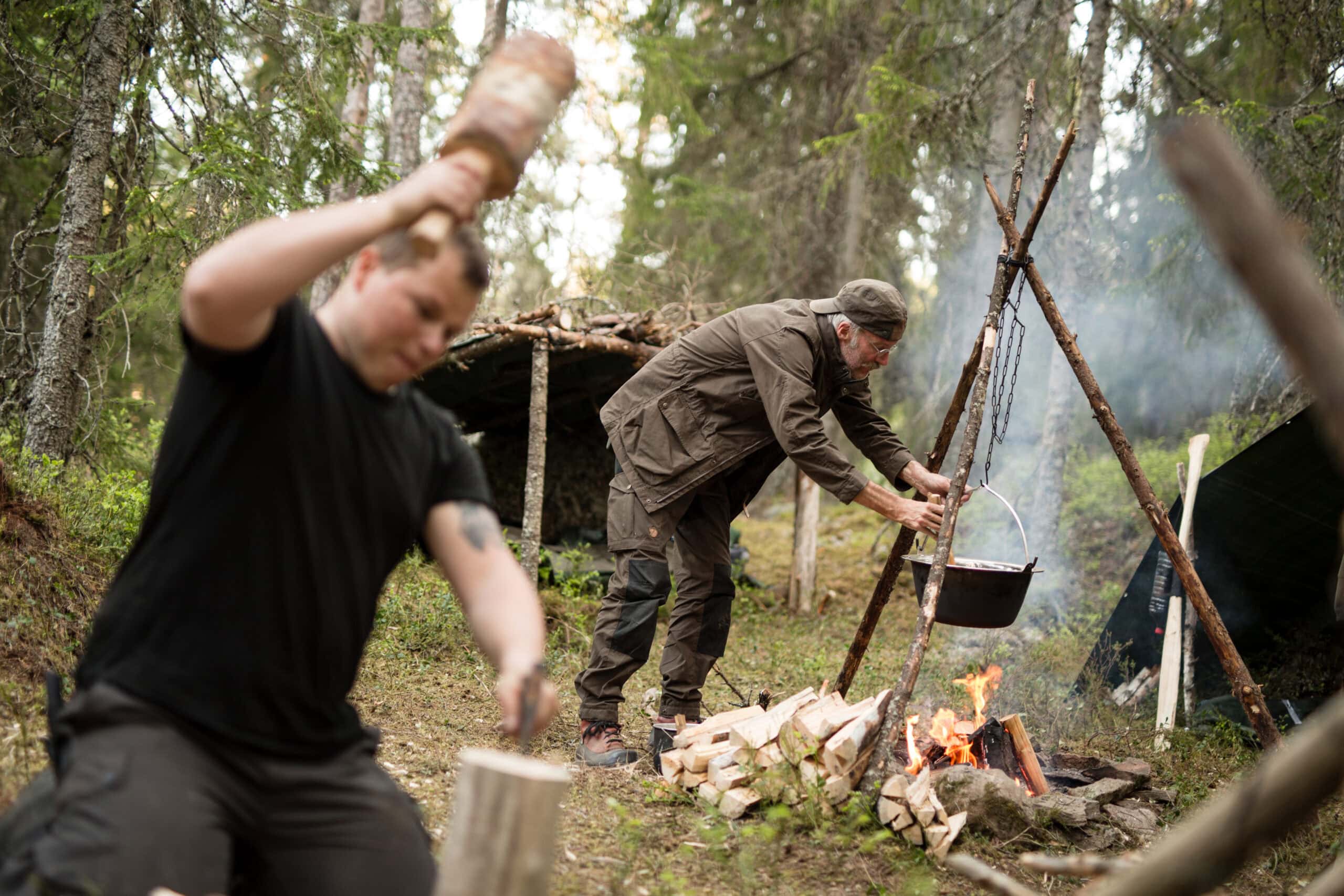 Teilnehmer kochen über offenem Feuer beim Survival Training der Wildnisschule Lupus in Brandenburg