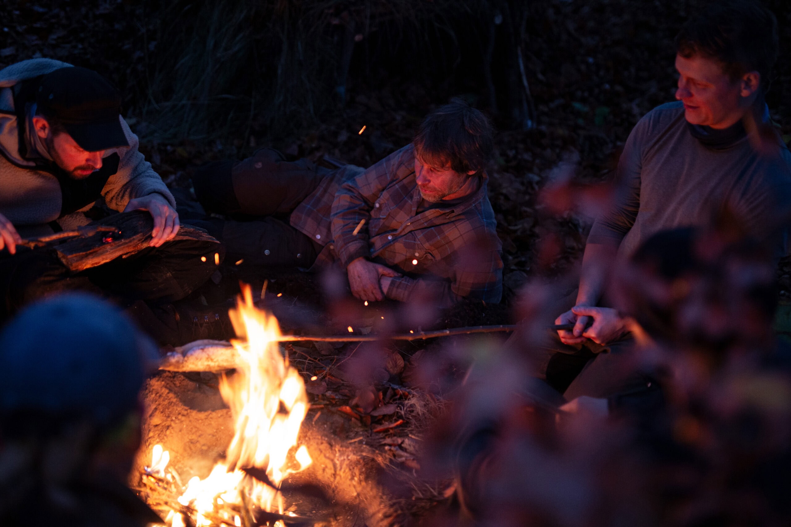 Teilnehmer am Lagerfeuer bei Nacht während des Survival Intensivkurses — 7 Tage Survival Camp bei Maurice Ressel