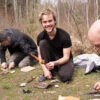 Teilnehmer beim Feuermachen im Survival Training — brennendes Zunderbündel aus Birkenrinde bei Maurice Ressel