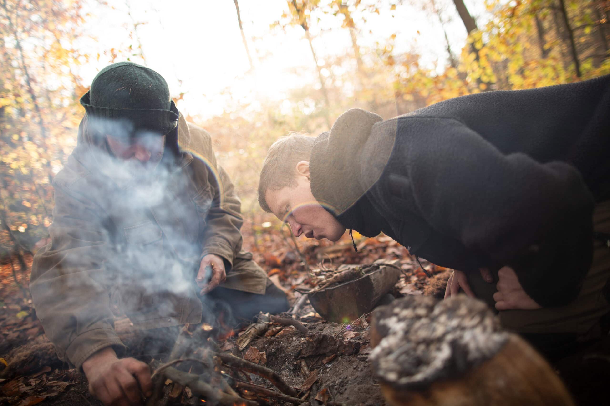 Teilnehmer beim Kochen am Lagerfeuer während des Survival Intensivkurses — Feldküche mit Naturmaterial unter realen Bedingungen